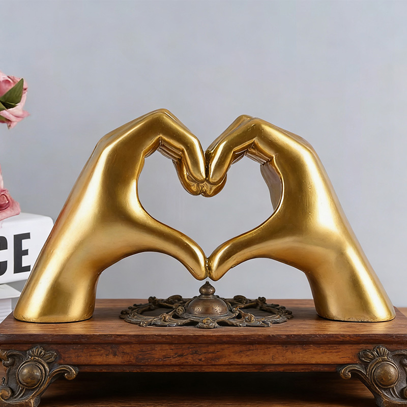 Mano de resina en forma de corazón dorado